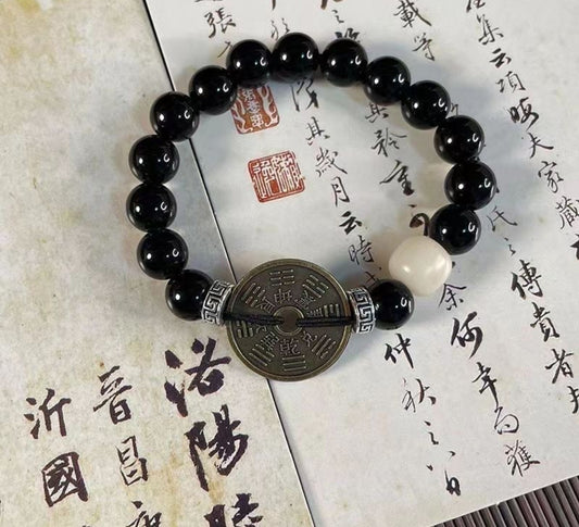 Bracelet talisman perles noires | pièce porte-bonheur en laiton